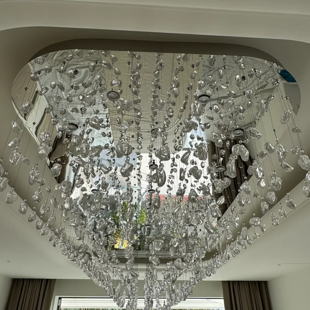 Vue du dessous d'un lustre cascade en verre installé en grande hauteur