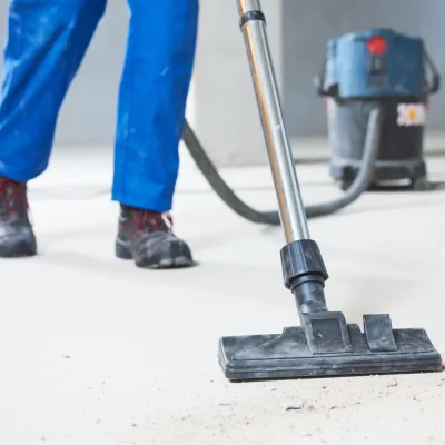 Technicienne Clean Pro aspirant l’eau sale sur un sol en marbre blanc après passage de la monobrosse dans un appartement à Cannes