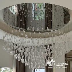 Grand lustre cascade à pampilles en verre suspendu sous un plafond miroir en double hauteur